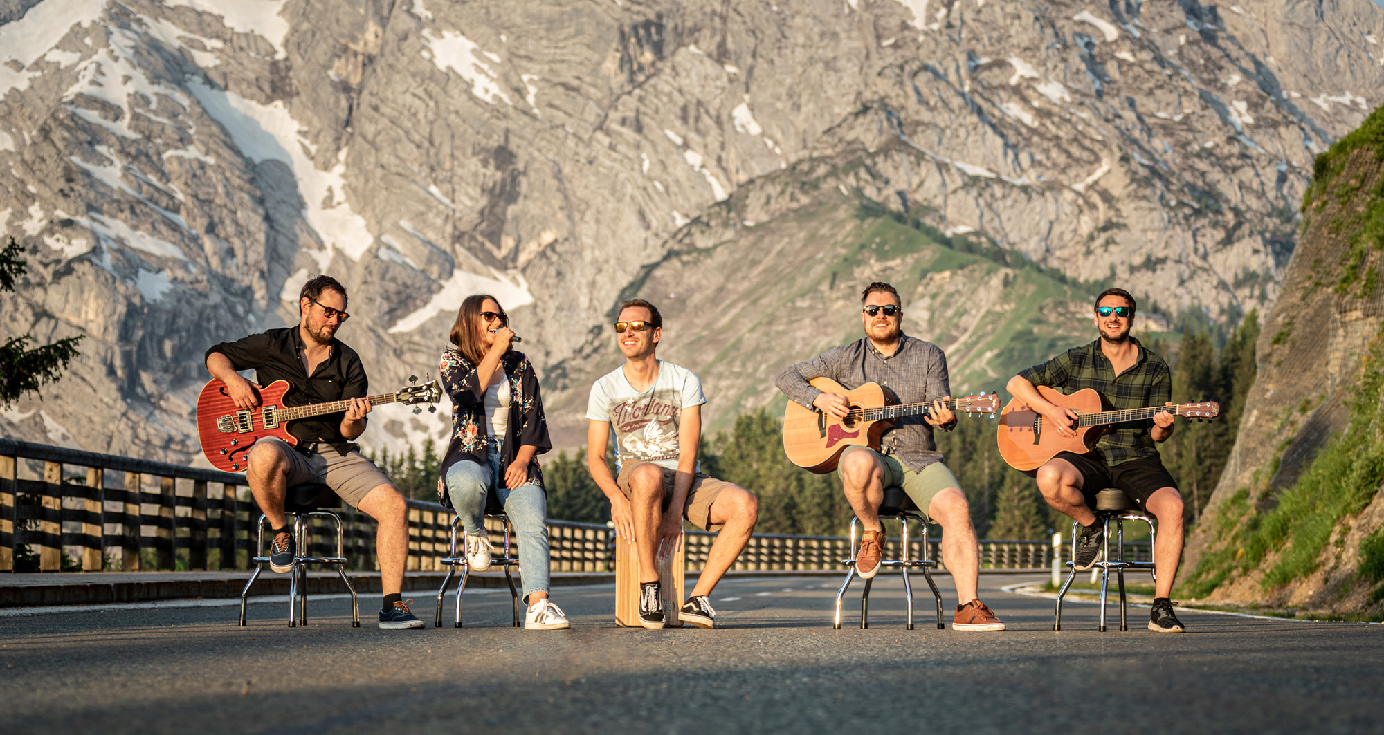 Gruppenfoto von der Band BAM Berchtesgaden Akustik Musik. Aufgereiht quer über die Strasse spielen alle 5 auf ihren Instrument